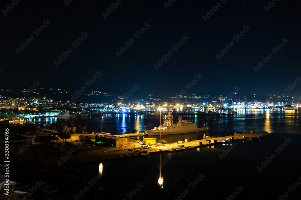 La Spezia Italy harbour port at night with military ships and city lights in the background