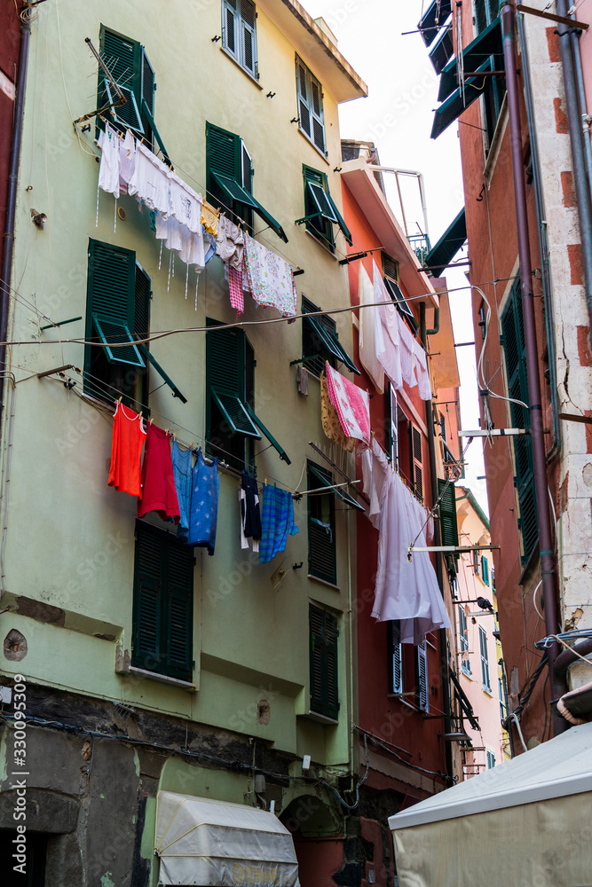 Colourful old buildings with clothing hanging lines in a small town Liguria region ofItaly on a slightly overcast summer day