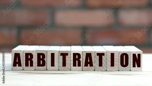concept word arbitration on cubes against the background of a brick wall photo