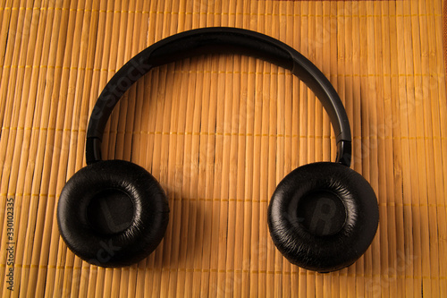 Black wireless headphones. Overhead, isolated professional-grade headphones. View from above.On a wooden background.