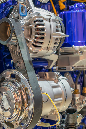 brand new, brilliant electric generator and starter on a car engine with gears and pulleys on belt drives with a motor
