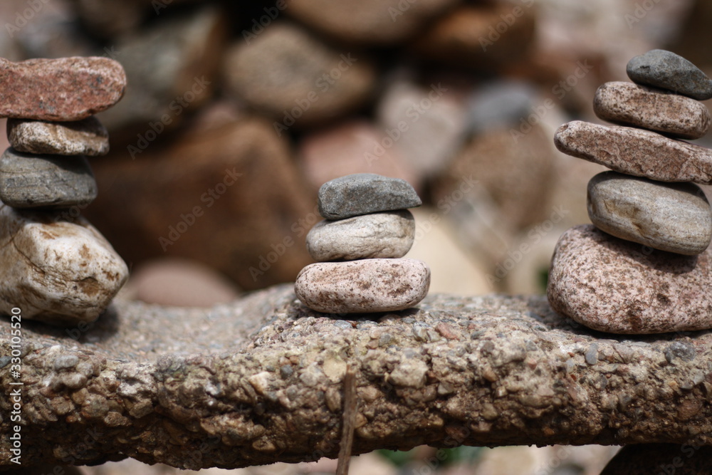 Three stacks of rock upon another rock Three stacks of rock upon another rock
