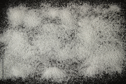 white sugar sprinkled on a black background