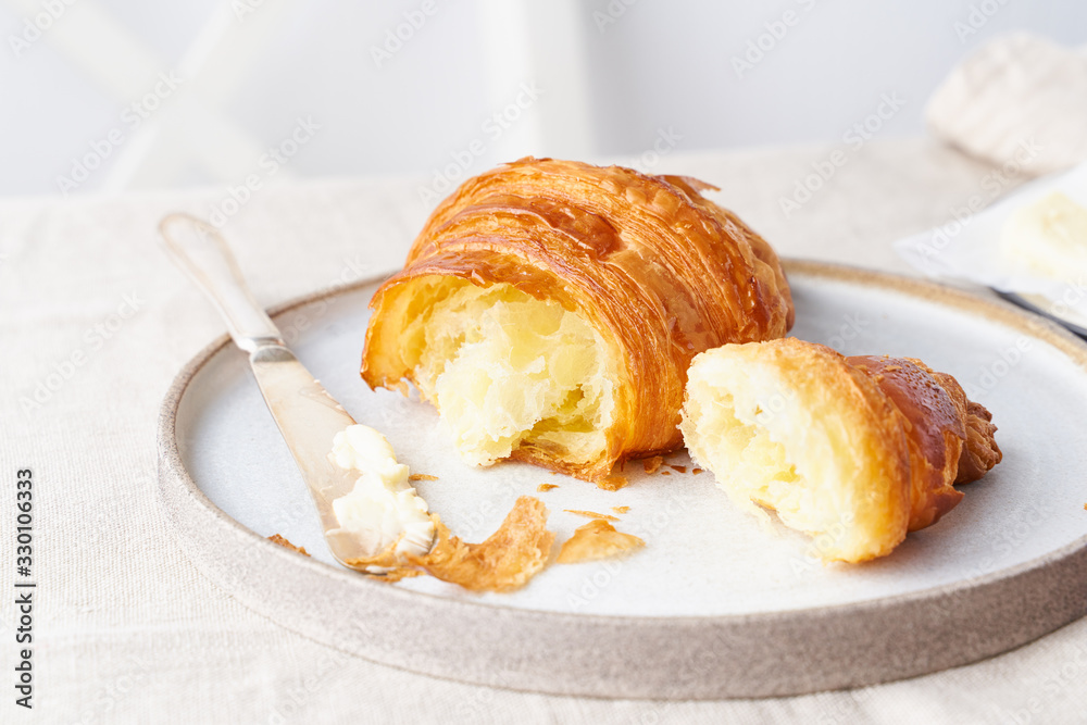 Coffee with croissant. Bright sunny morning, leisurely breakfast with fresh pastries, side view Coffee with croissant. Bright sunny morning, leisurely breakfast with fresh pastries, side view
