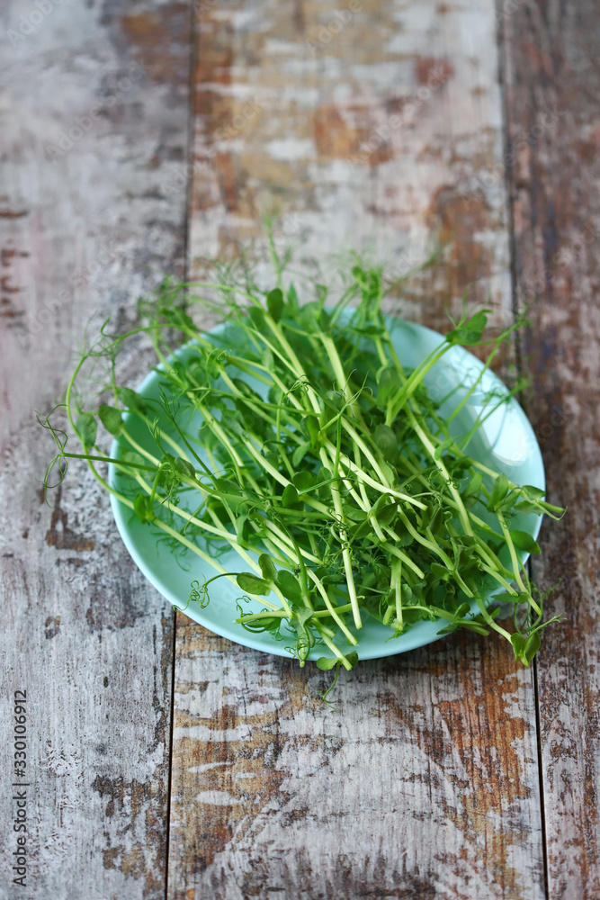 Plate with microgreens on a wooden surface. Plate with microgreens on a wooden surface.
