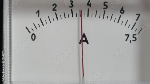 The arrow of the ammeter sharply deviates when voltage is turned on in electrical equipment. Readings of analog device change during load operation. Current Indicator in Lead Acid Car Battery Charger