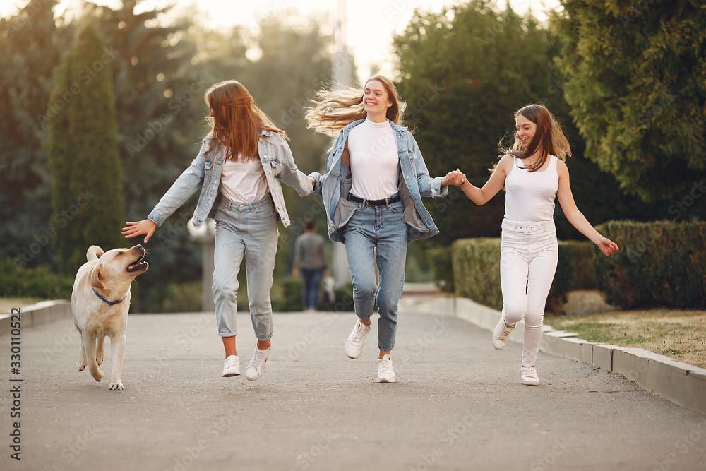 Obraz premium Beautiful girls walking. Women in a spring city. Ladies with cute dog.