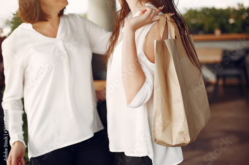 Women in a white blouses. Ladies with shopping bags. Mother with daughter.