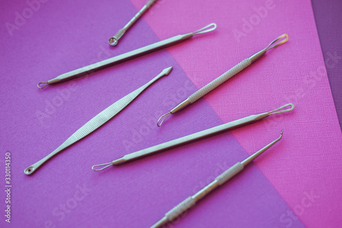 Tools for removing acne. Tools of the cosmetologist for problem skin on pink paper background.