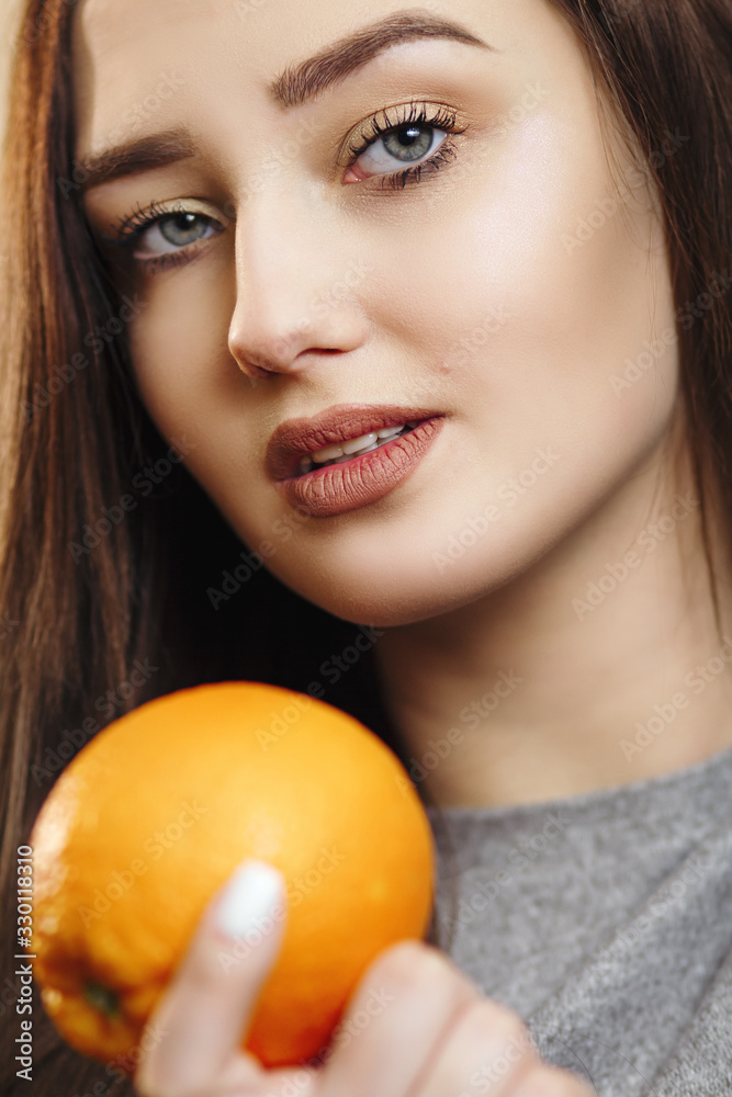 portrait of a beautiful fashionable girl with long hair and orange, young woman smiling and holding fruit, healthy eating concept and female beauty portrait of a beautiful fashionable girl with long hair and orange, young woman smiling and holding fruit, healthy eating concept and female beauty