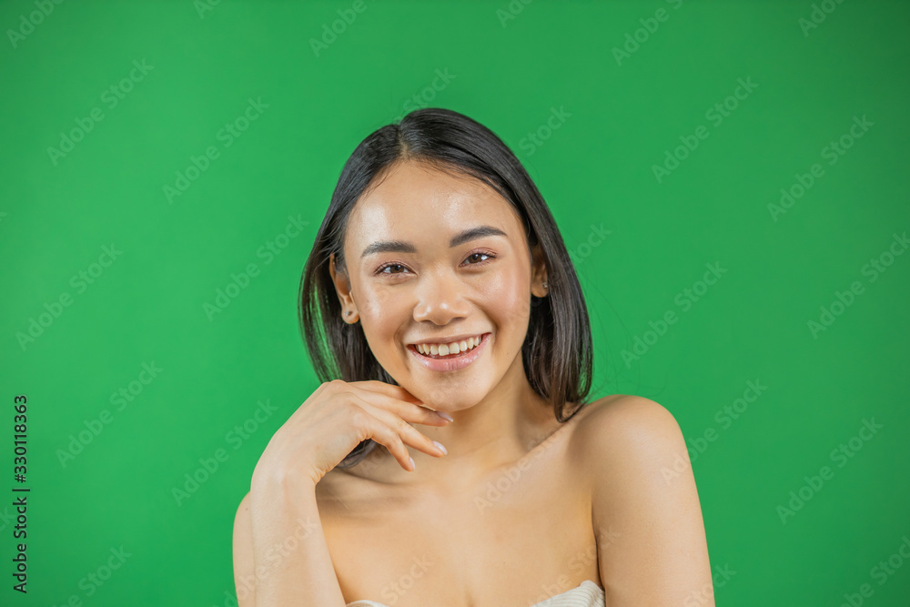 Asian woman smiling and looking at camera isolated on green background Asian woman smiling and looking at camera isolated on green background
