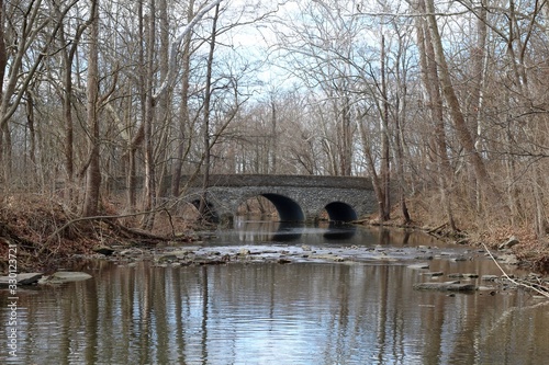 The stone bridge and the creek in the woods of the park.