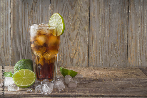 Фотография Summer iced alcohol drink with cola and lime