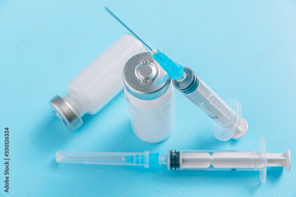 two syringes and two ampoules with medicine without a label on a blue background the concept of a coronavirus vaccine two syringes and two ampoules with medicine without a label on a blue background the concept of a coronavirus vaccine