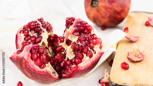 ripe red pomegranate on a white wooden table