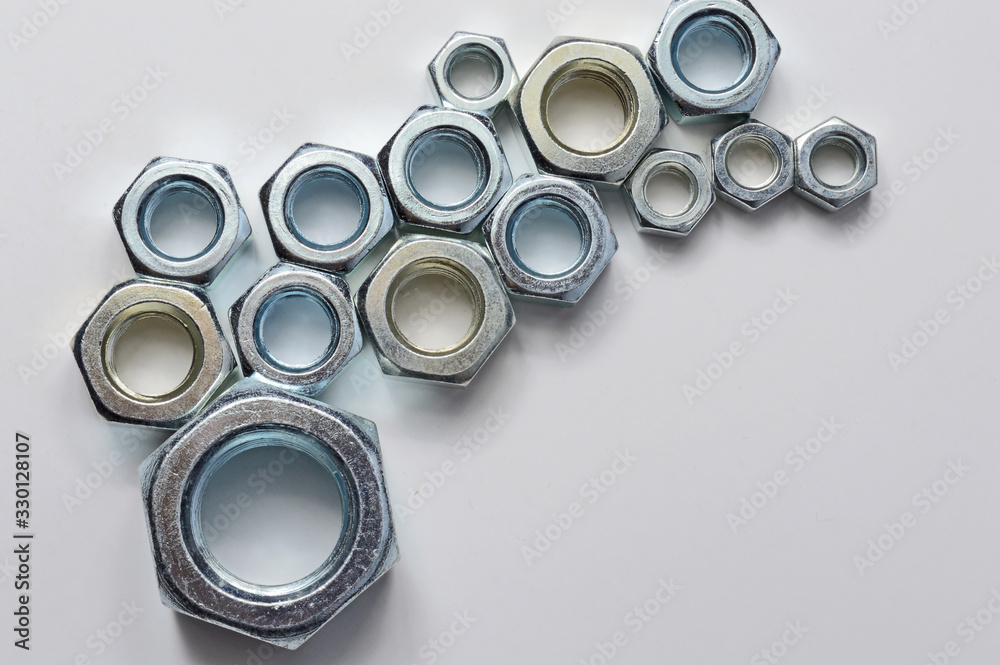 New chrome screw-nut of different sizes on a white background. Concept. New chrome screw-nut of different sizes on a white background. Concept.