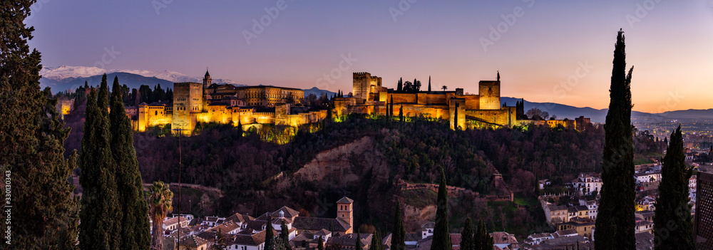 Alhambra sunset in granada Spain with snow capped mountains in background, monument