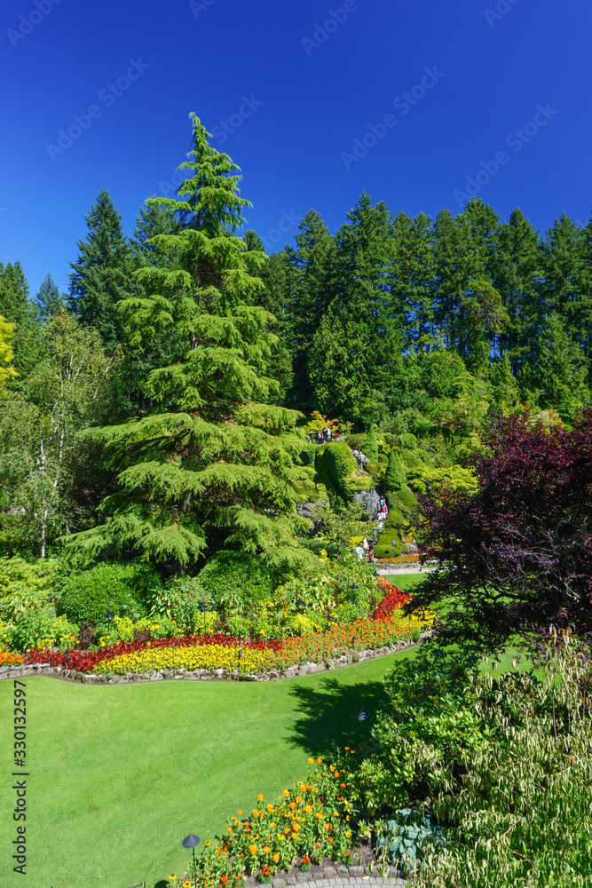 Brentwood Bay, British Columbia, Canada: A small group of visitors exploring the Sunken Garden at The Butchart Gardens, a National Historic Site of Canada.