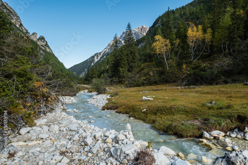 Babbling stream, autumn colors in the valley of Italian Dolomites