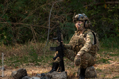 soldier in camouflage aiming with rifle