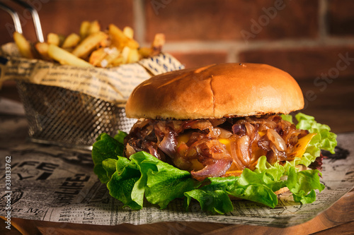 Tableau sur toile Burger with beef and caramelized onions on a wooden board