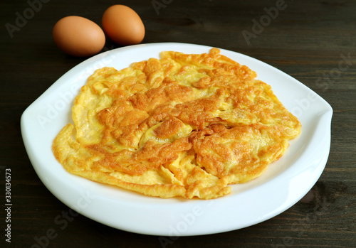 Plate of Thai Style Omelette on the Dark Brown Wooden Table