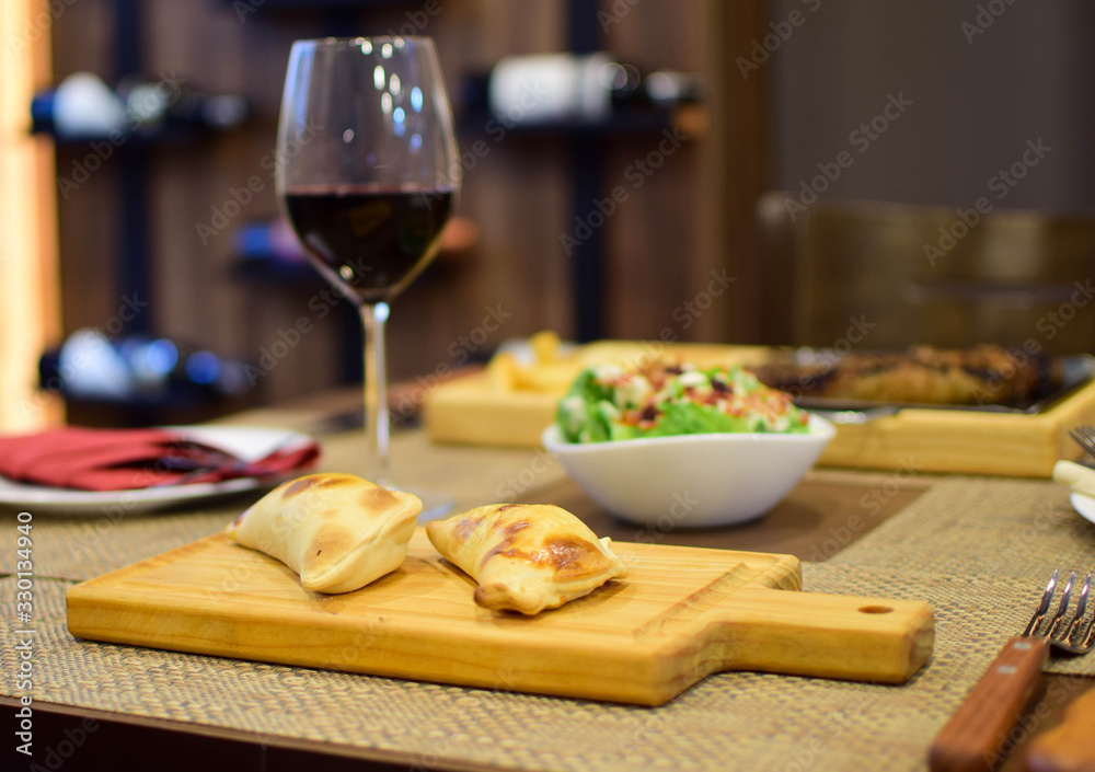 Argentine empanadas with a glass of wine and salads