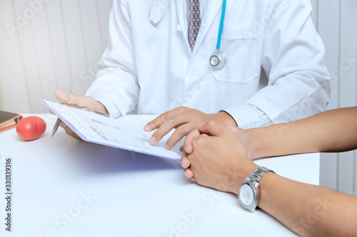 A doctor consults patient while sitting at the table in office. Medicine and health care concept.
