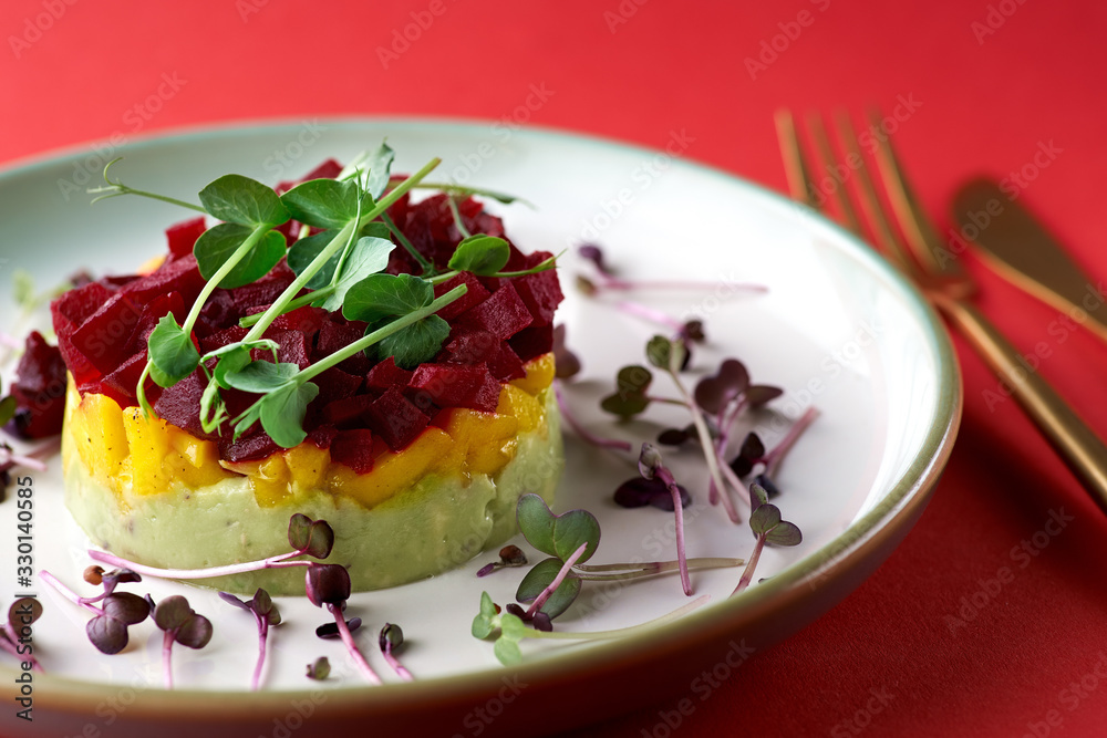 Fresh Tartar tricolor from avocado, mango and beet, selective focus