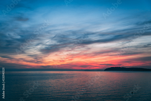 Sunset over the sea  colorful clouds  wide shot. Romantic picture full of colors.