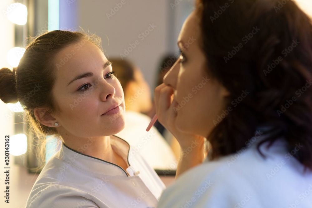 Female make up artist working on model in salon Female make up artist working on model in salon