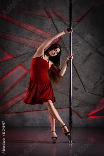 Beautiful girl dancing on the pole at studio