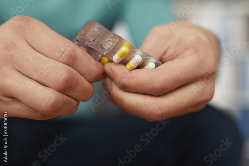 Close-up of man is ill and he is going to drink some medicine from headache