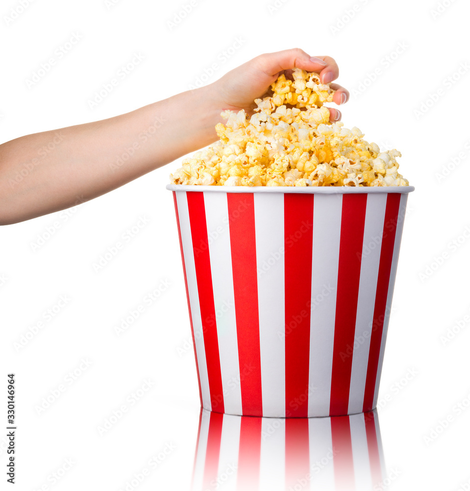 Woman hand picking popcorn from striped bucket isolated on white background Woman hand picking popcorn from striped bucket isolated on white background
