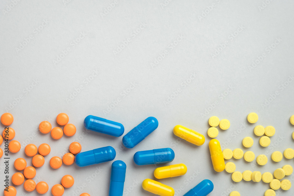 Colorful pills and capsules, medication on gray background with copy space. Health and medication concept. Top view. Colorful pills and capsules, medication on gray background with copy space. Health and medication concept. Top view.