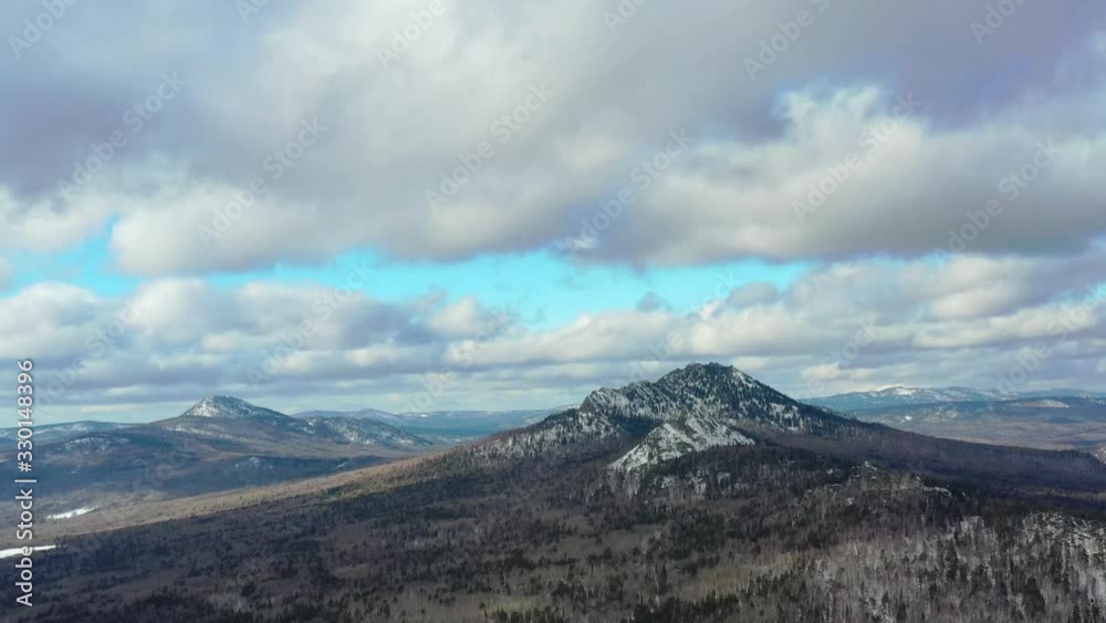 Thick clouds float over the snowy mountains and pine forest Thick clouds float over the snowy mountains and pine forest