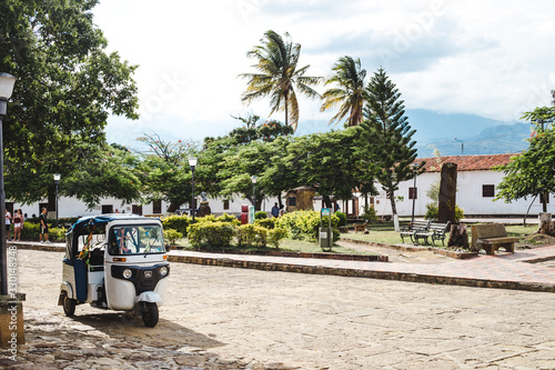 Tuktuk waits for a passenger on the edge of the main square plaza of Guane, a small typical town in the Santander region of Colombia photo
