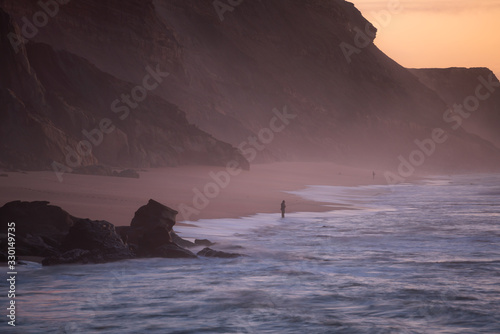 Fishermen in Santa Cruz beach at sunset, in Portugal