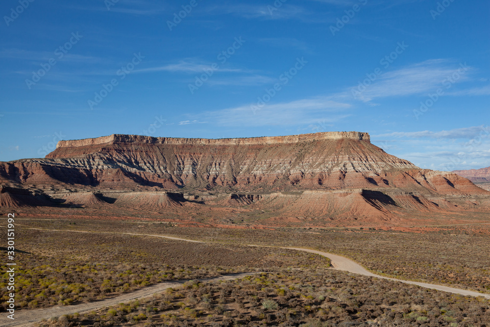 Amazing canyon shaped like a natural theater in the background, dirt roads intersecting in the foreground of the desert Amazing canyon shaped like a natural theater in the background, dirt roads intersecting in the foreground of the desert