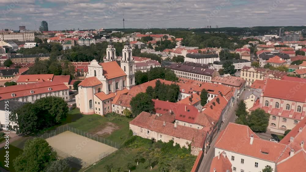 VILNIUS, LITHUANIA - JULY, 2019: Aerial view of the church of St. Catherine and roofs of the old city centre of Vilnius. VILNIUS, LITHUANIA - JULY, 2019: Aerial view of the church of St. Catherine and roofs of the old city centre of Vilnius.
