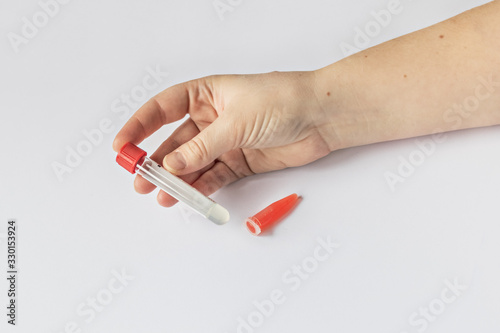 Laboratory tubes in the doctor   s hand with blood serum  with the inscription  CORONAVIRUS   infected patient. Blood test for COVID-19. Pandemic.