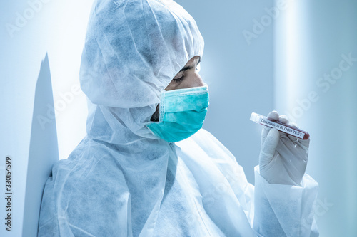 medico con tuta protettiva e mascherina tiene in mano una provetta per il test del sangue del coronavirus -    photo