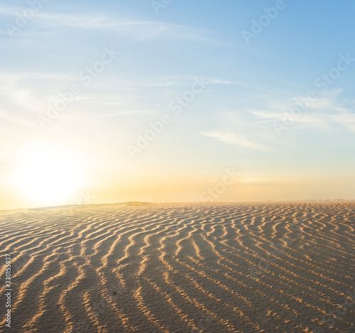 wavy sandy desert landscape at the sunset
