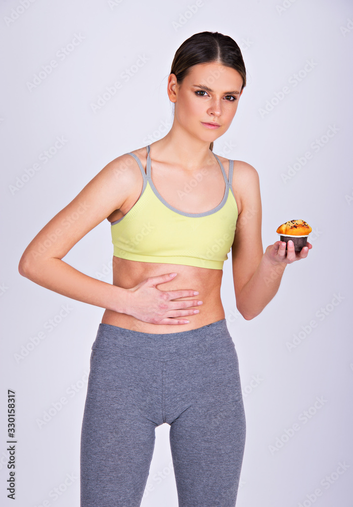young fit woman holding her stomach, abdominal pain caused by food, gluten free concept, isolated on white young fit woman holding her stomach, abdominal pain caused by food, gluten free concept, isolated on white