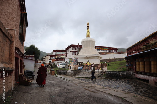 Traditional temple in Tibetan town. Tibetan village in China Sichuan province. Monk and people