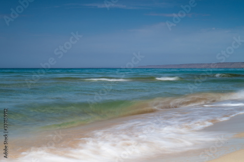 View of blue sea waves at sandy beach. Horizon line. Caspian Sea, sandstone coast. ustyurt. Selective focus, long shutter speed