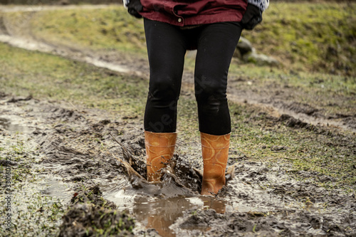 woman jumping in the puddle of mud