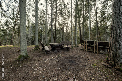 resting camping place in the woods with benches and trail in late autumn