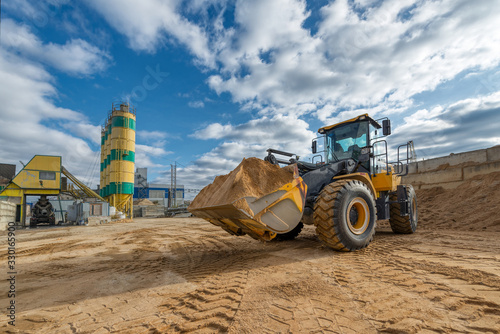 Obraz na plátně A wheel loader carries a full bucket of sand. T