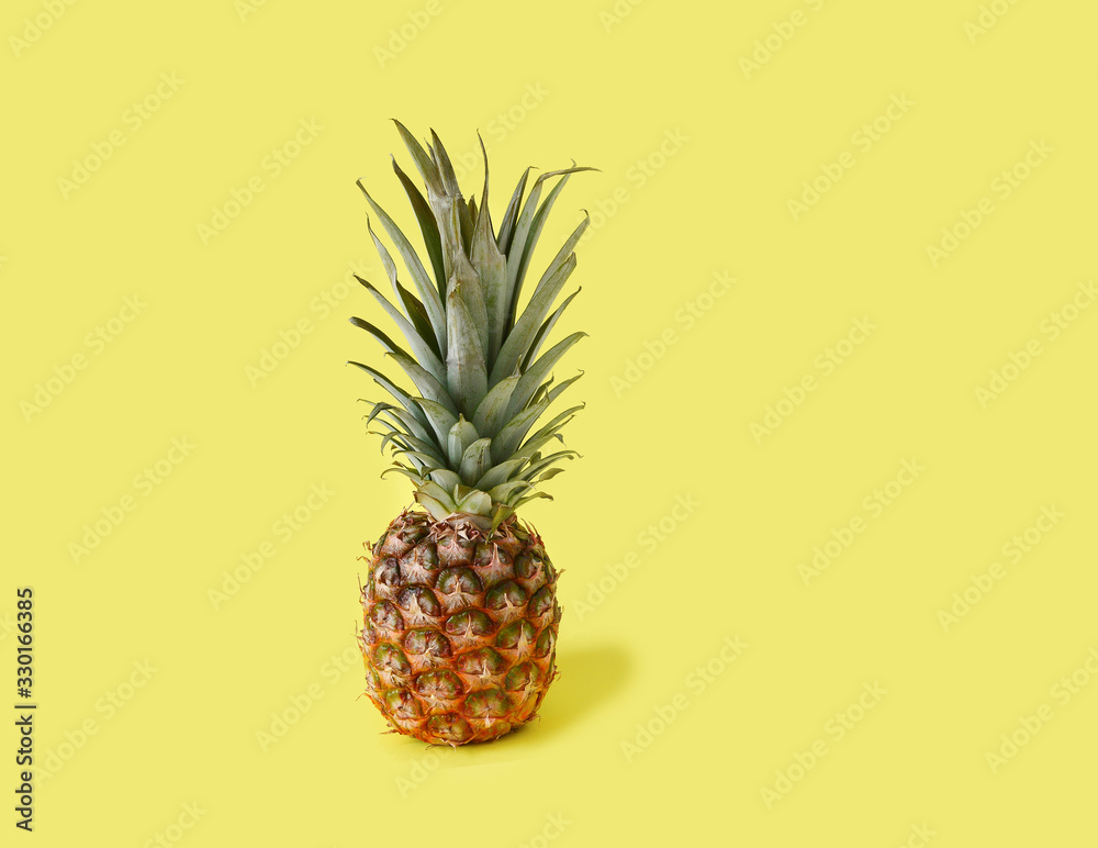 Whole Pineapple on Yellow Background.Copy space.
